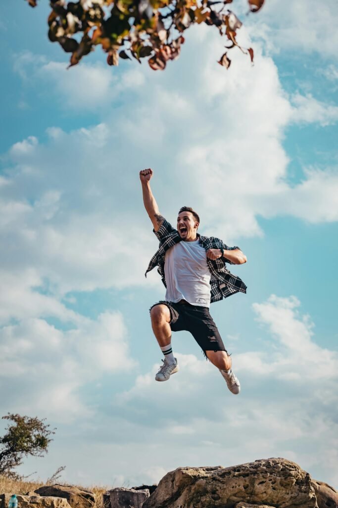 A vibrant image of a young man jumping with joy outdoors, capturing a moment of freedom and exhilaration.